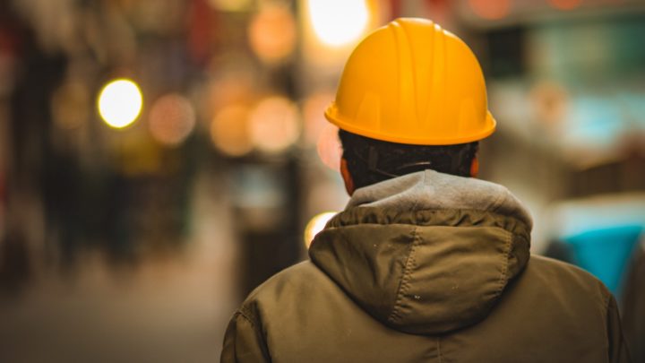 person in yellow hard hat and brown jacket